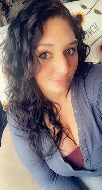 a woman with long curly hair posing for a photo